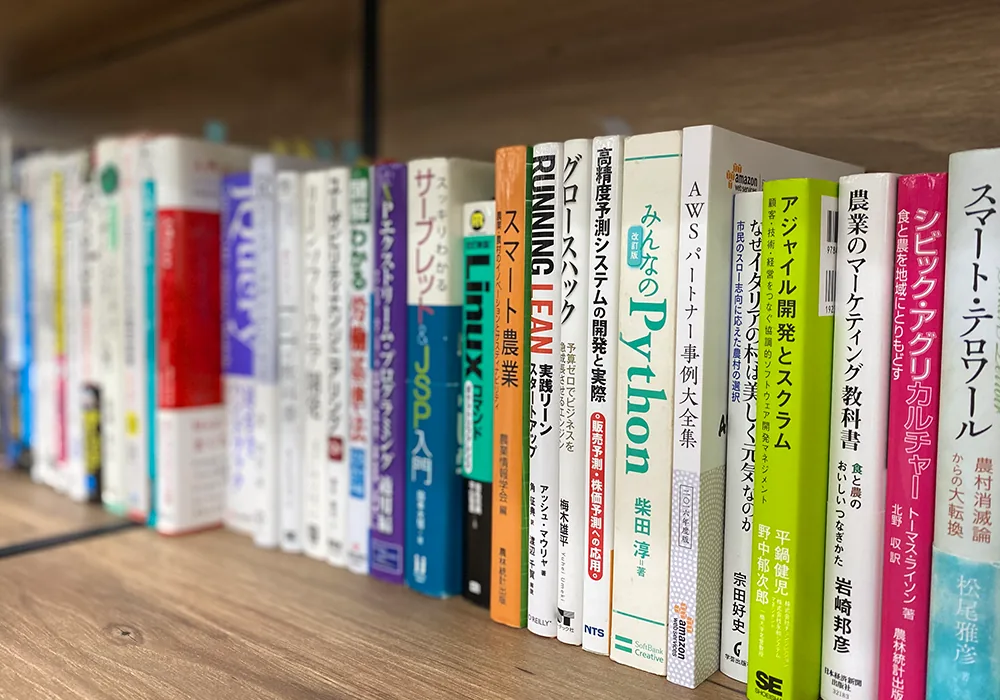 社内の本棚に並ぶ技術書とビジネス書。Python・AWS・Linux・アジャイル開発から、スマート農業やマーケティングの書籍まで